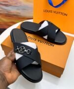 Sneakers, loafers, and slip-ons in black leather, featuring a distinctive cross-stitch pattern and a silver buckle closure. Designed for both men and women, these sandals are perfect for everyday wear or special occasions.