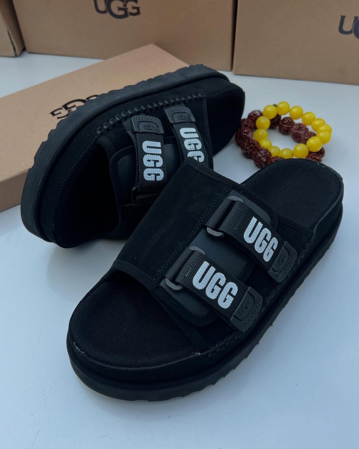 Sneakers, loafers, and slip-ons in black, perfect for any Nigerian wardrobe. Ugg's signature 'UGG' is featured on the straps, adding a touch of personality.