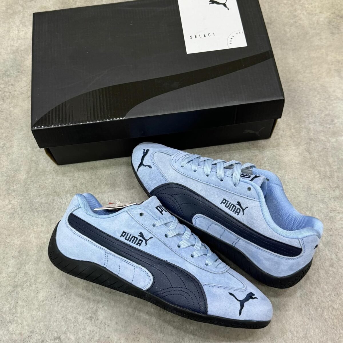 Sneakers/loafers in light blue and black, perfect for driving or everyday wear. Puma's signature logo adds a touch of style and quality.