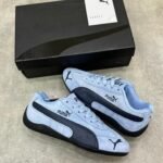 Sneakers/loafers in light blue and black, perfect for driving or everyday wear. Puma's signature logo adds a touch of style and quality.